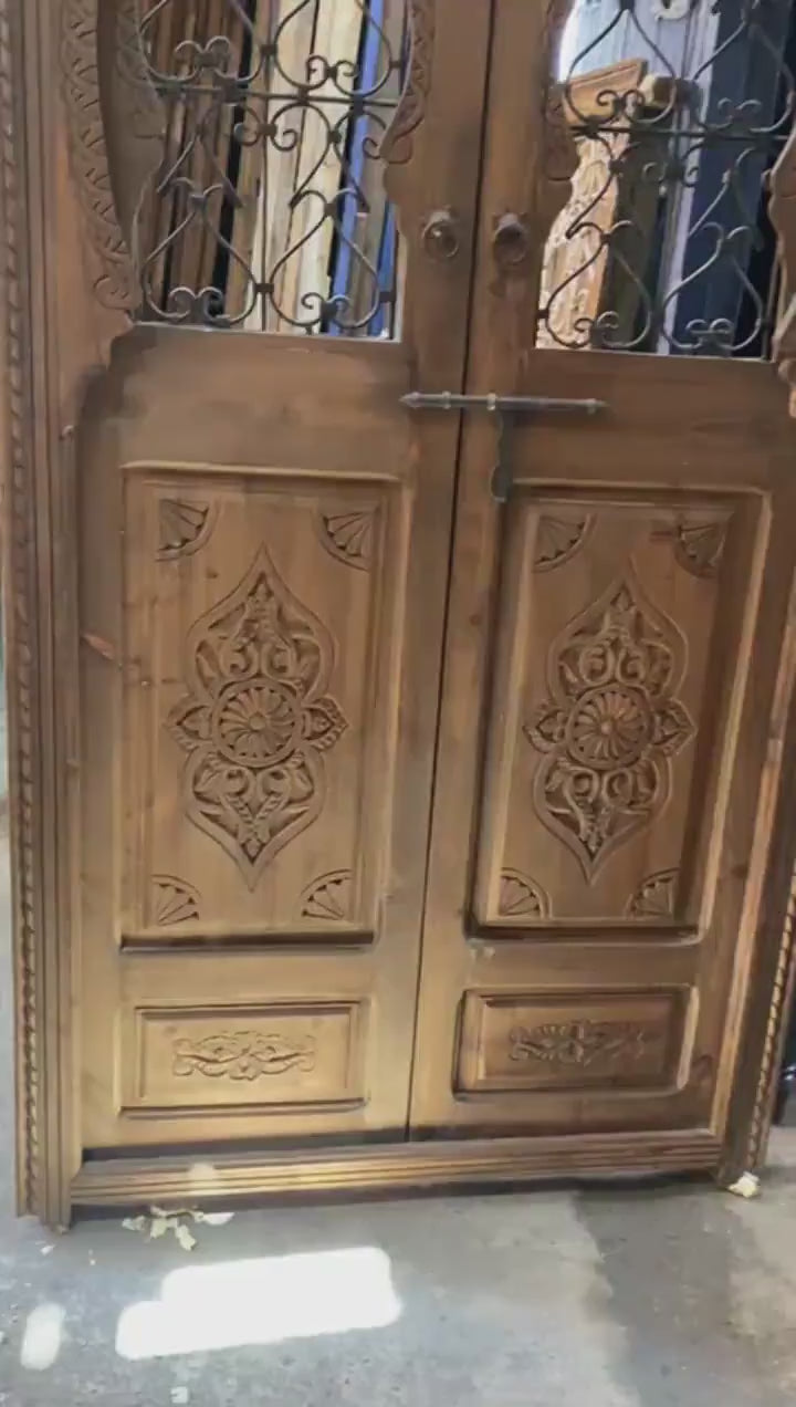Porte marocaine traditionnelle Porte en bois sculptée , avec deux fenêtres en fer forgé travaillé a main . wall decor
