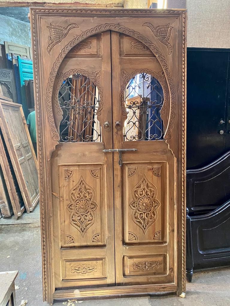 Porte marocaine traditionnelle Porte en bois sculptée , avec deux fenêtres en fer forgé travaillé a main . wall decor